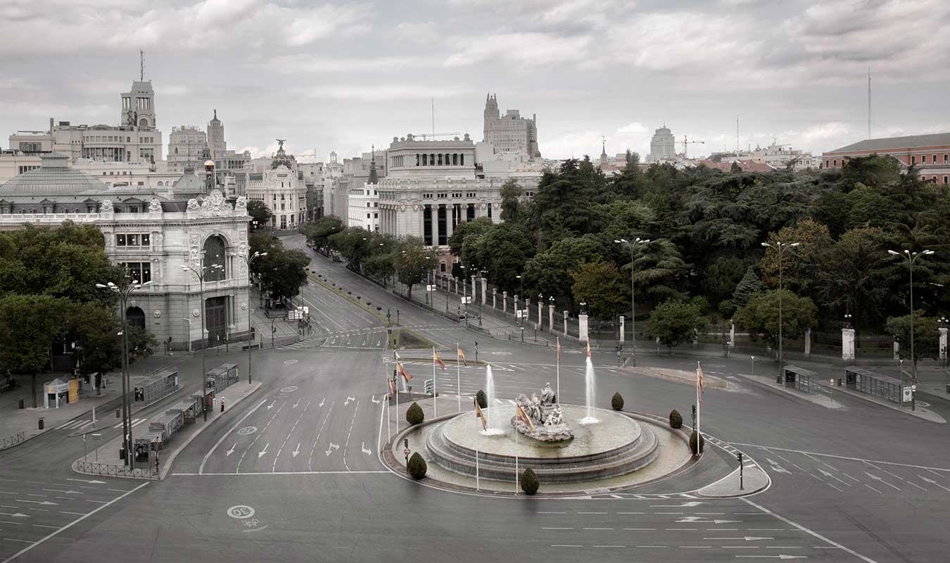 Foto de la plaza de Cibeles en Madrid con una sola persona esperando el autobus