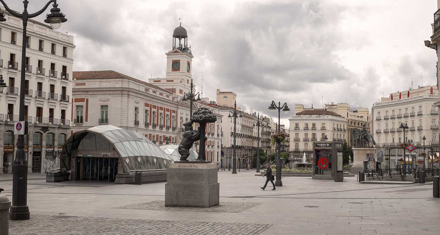 Foto de la Puerta del Sol en Madrid con un solo vioandante cruzando la plaza